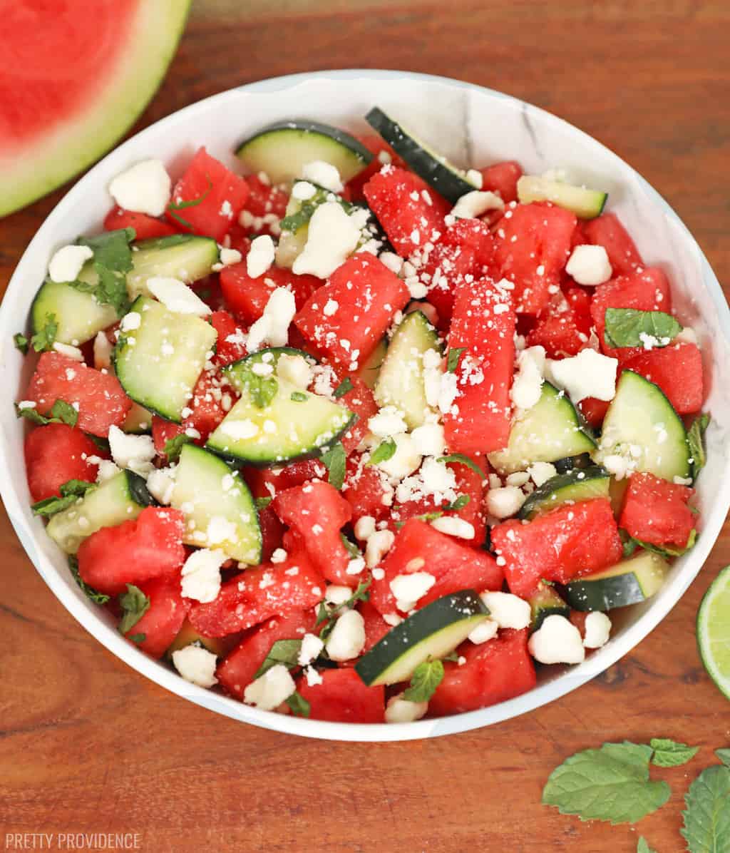 Watermelon feta salad with cucumber and mint in a white bowl.