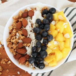 Yogurt with toppings: pineapple, blueberries, coconut, almonds, granola.