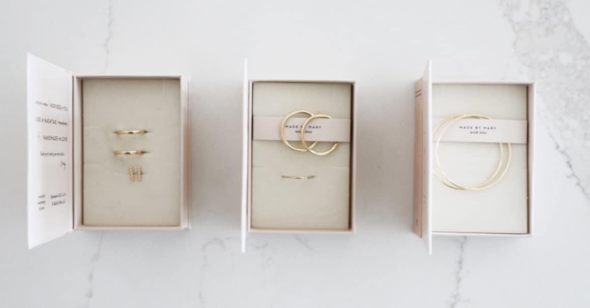 Three boxes of Made by Mary jewelry with the lids opened to one side.