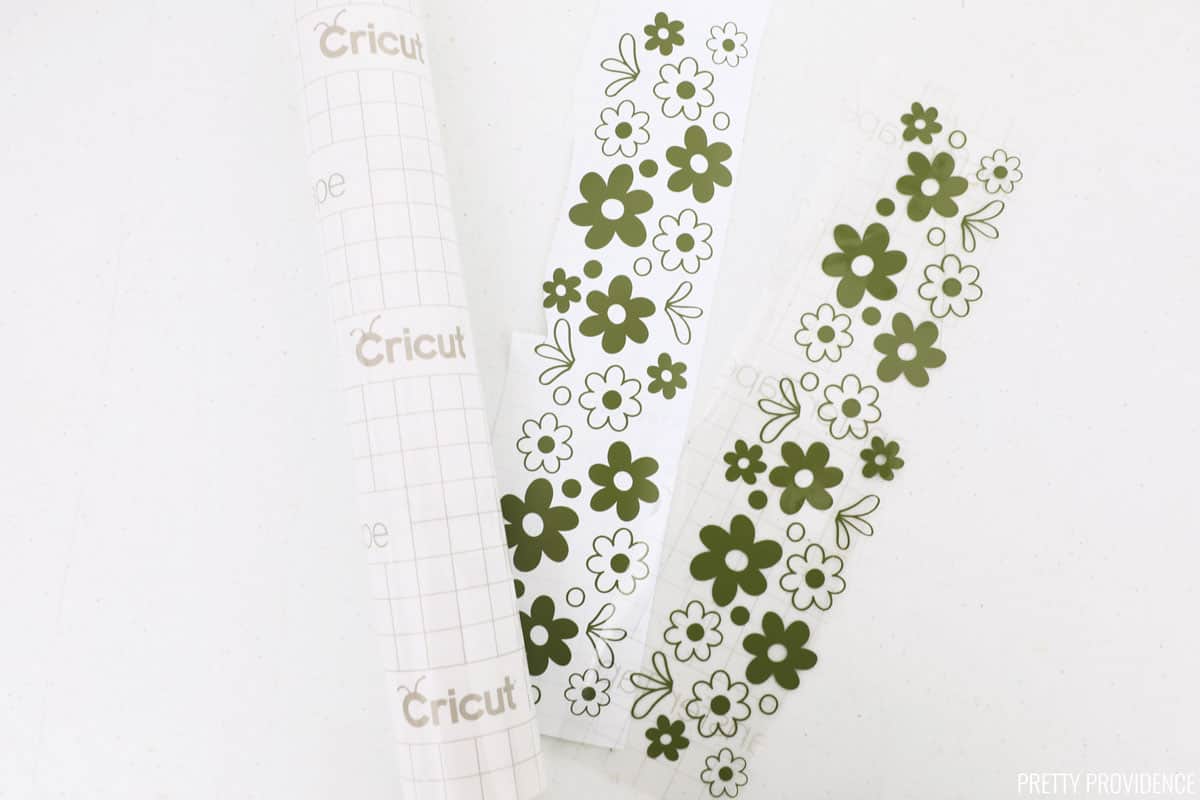 Cricut transfer tape roll and two strips of green vinyl in a vintage pyrex pattern.