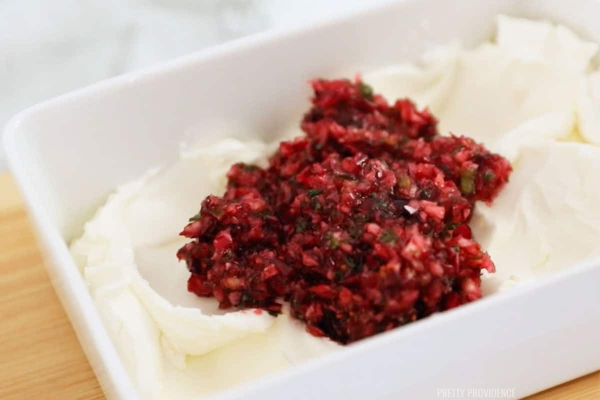 Cranberry Jalapeño Dip on top of cream cheese in a white dish.