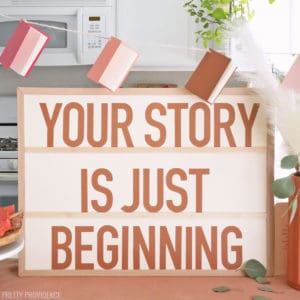 Baby Shower Sign that says 'Your Story is Just Beginning' with book baby shower decorations.