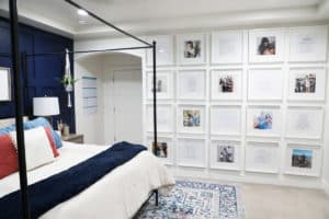 A side view of a large scale gallery wall in a master bedroom.