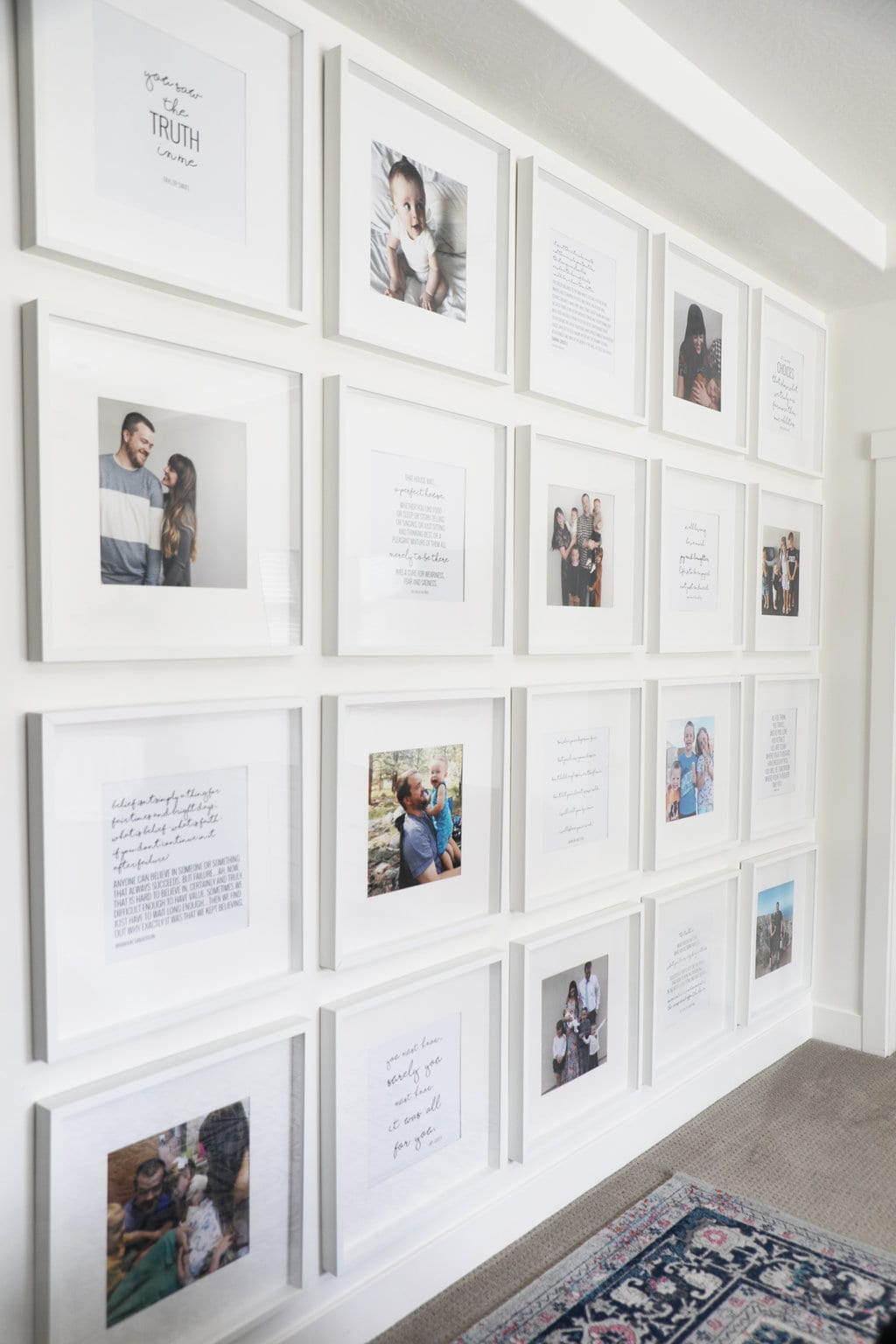 A large scale gallery wall with square white frames spaced evenly across a white wall. 