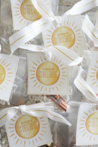 A stack of good luck gifts for a dance or cheer team with yellow sun free printables.