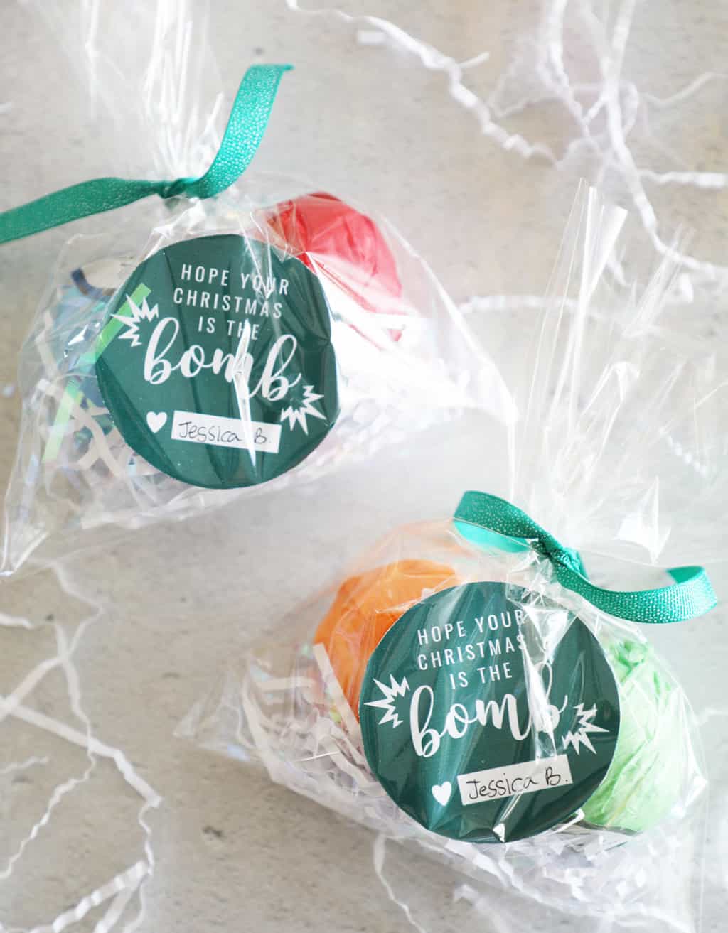Two small bath bomb gifts with green circular tags tied with green ribbon.