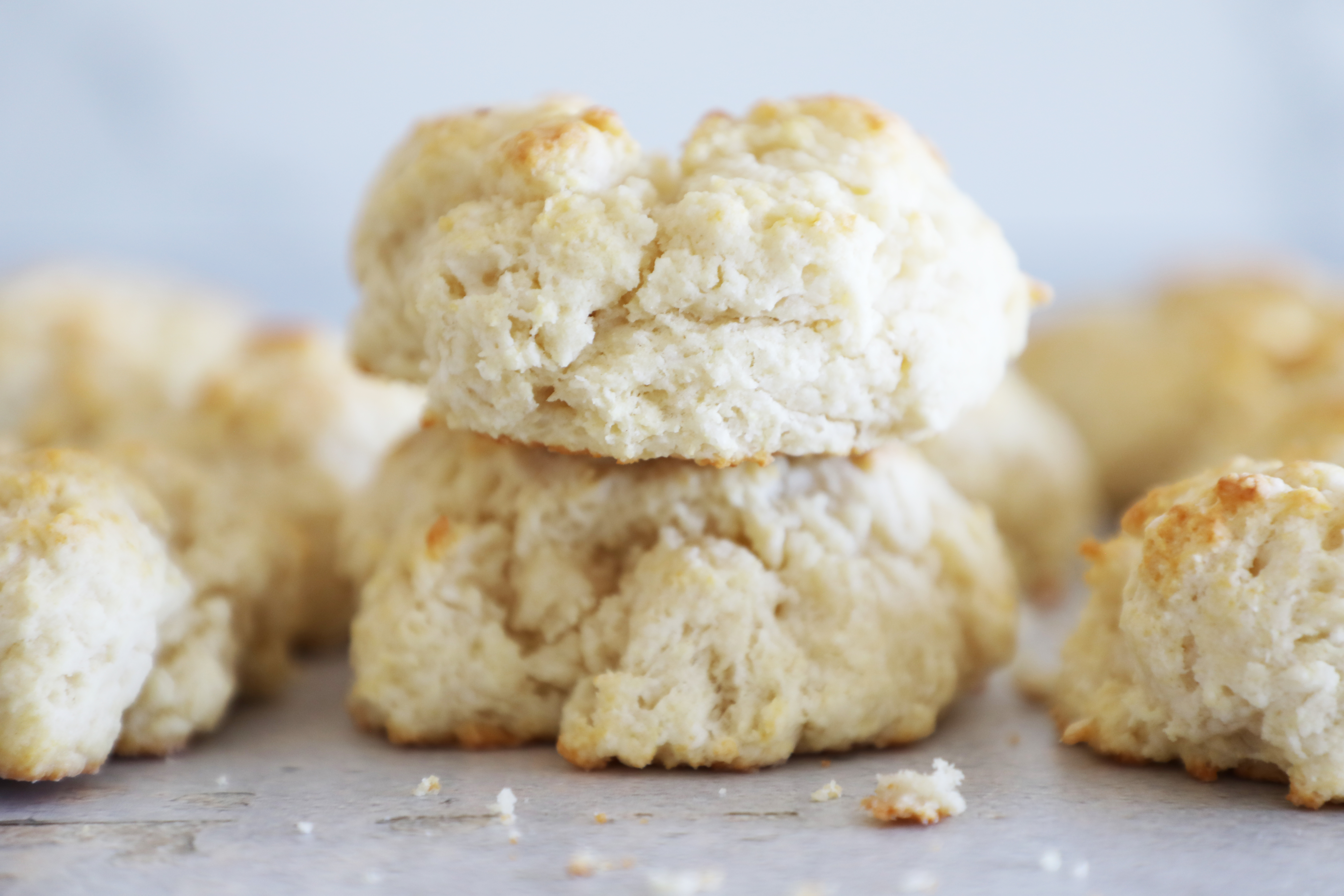 Several homemade biscuits gathered on a concrete countertop.