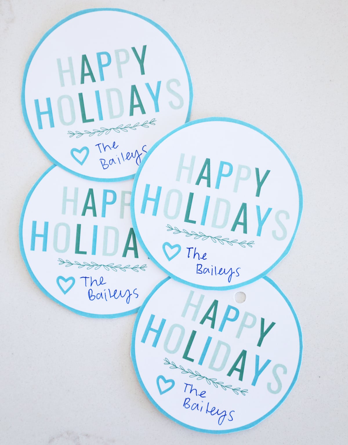 Circular gift tags that say "Happy Holidays" in various shades of blue and green.