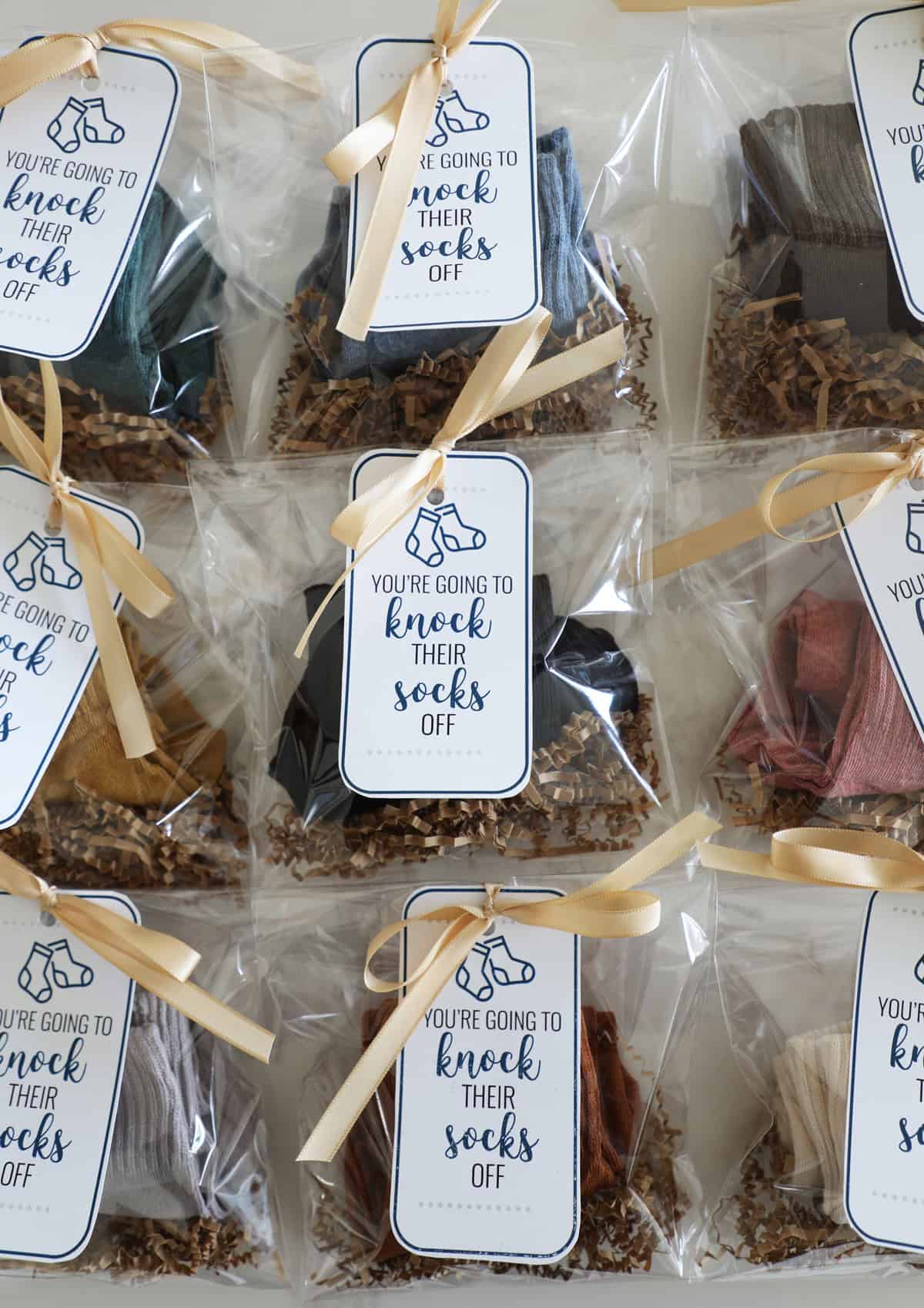 Three rows of socks in cellophane bags tied with cute ribbons and gift tags.