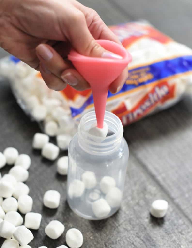mini marshmallows being put into a baby bottle with a snot sucker.