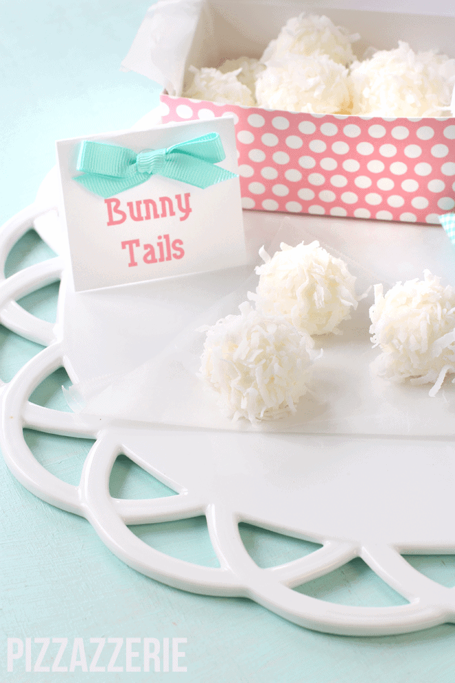Easter bunny tails on a white plate next to a sign.