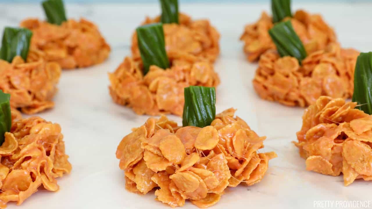 pumpkin-shaped treats made with cornflakes and melted marshmallow topped with green licorice stems.