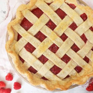 raspberry pie with a golden crust in a criss cross pattern.