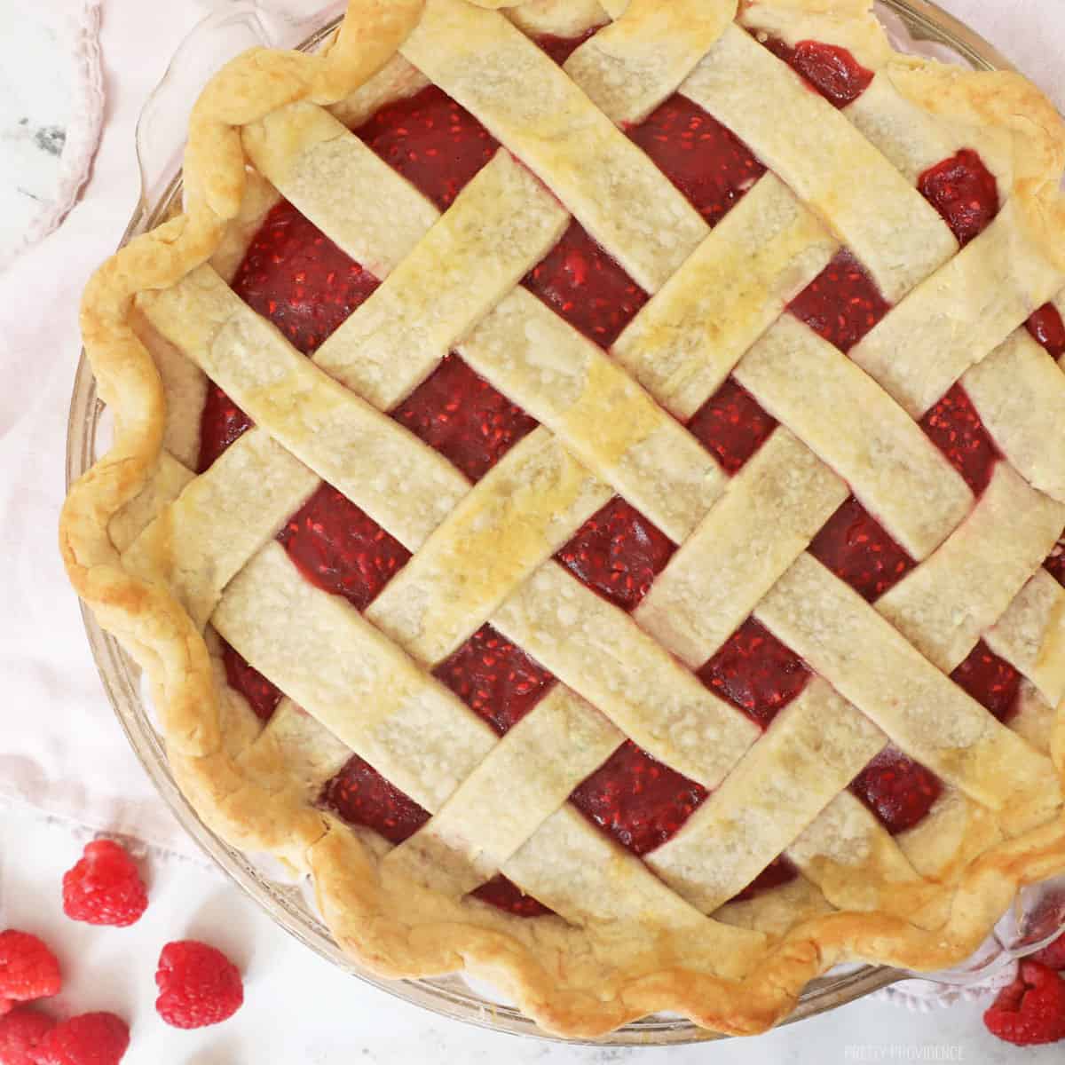 Raspberry pie filling in a criss-cross pie crust. 