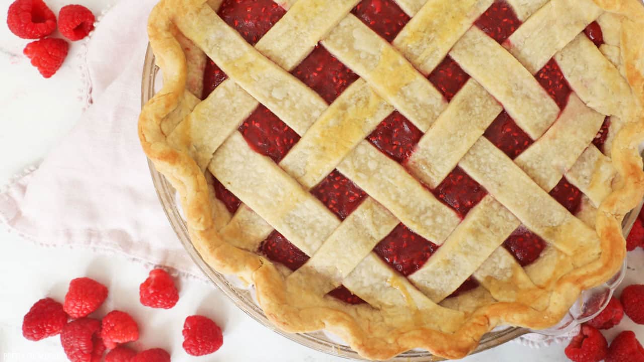 Raspberry pie filling in a criss-cross pie crust. 