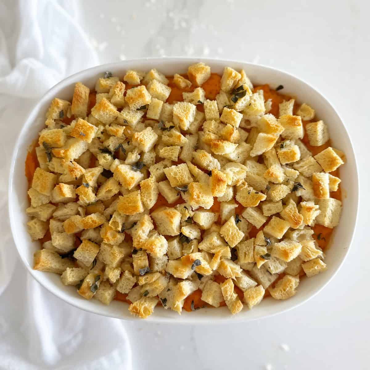 Bird's eye view of a savory sweet potato recipe with sage breadcrumbs on top. 