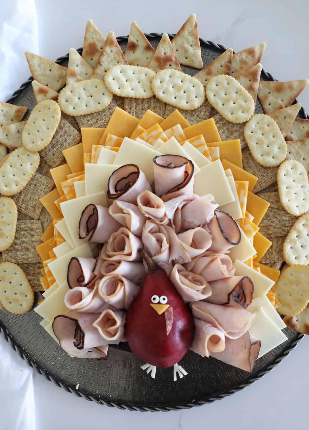 Bird's eye view of a Thanksgiving cheese board styled to look like a turkey. 