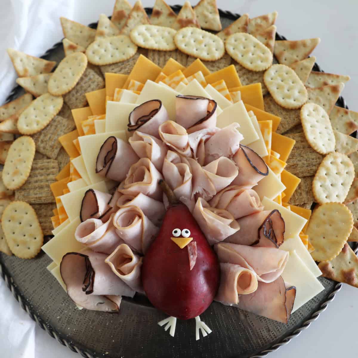 A bird's eye view of a turkey cheese platter modeled to look like a Thanksgiving Turkey. 