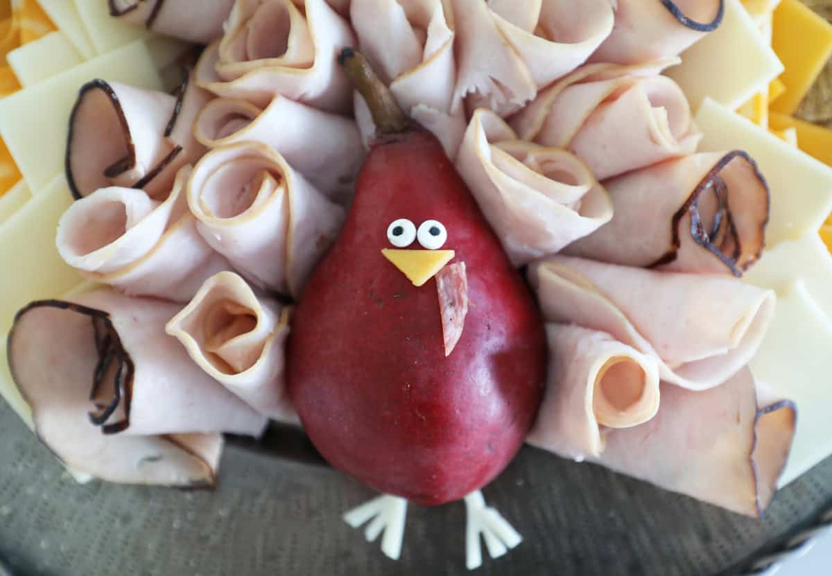 Close up of a Turkey made from a pear, edible eyes, cheese, salami and walnuts. 