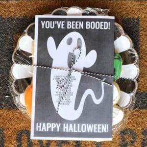 you've been boo'd sign tied onto a plate of Halloween cookies on a brown door mat.