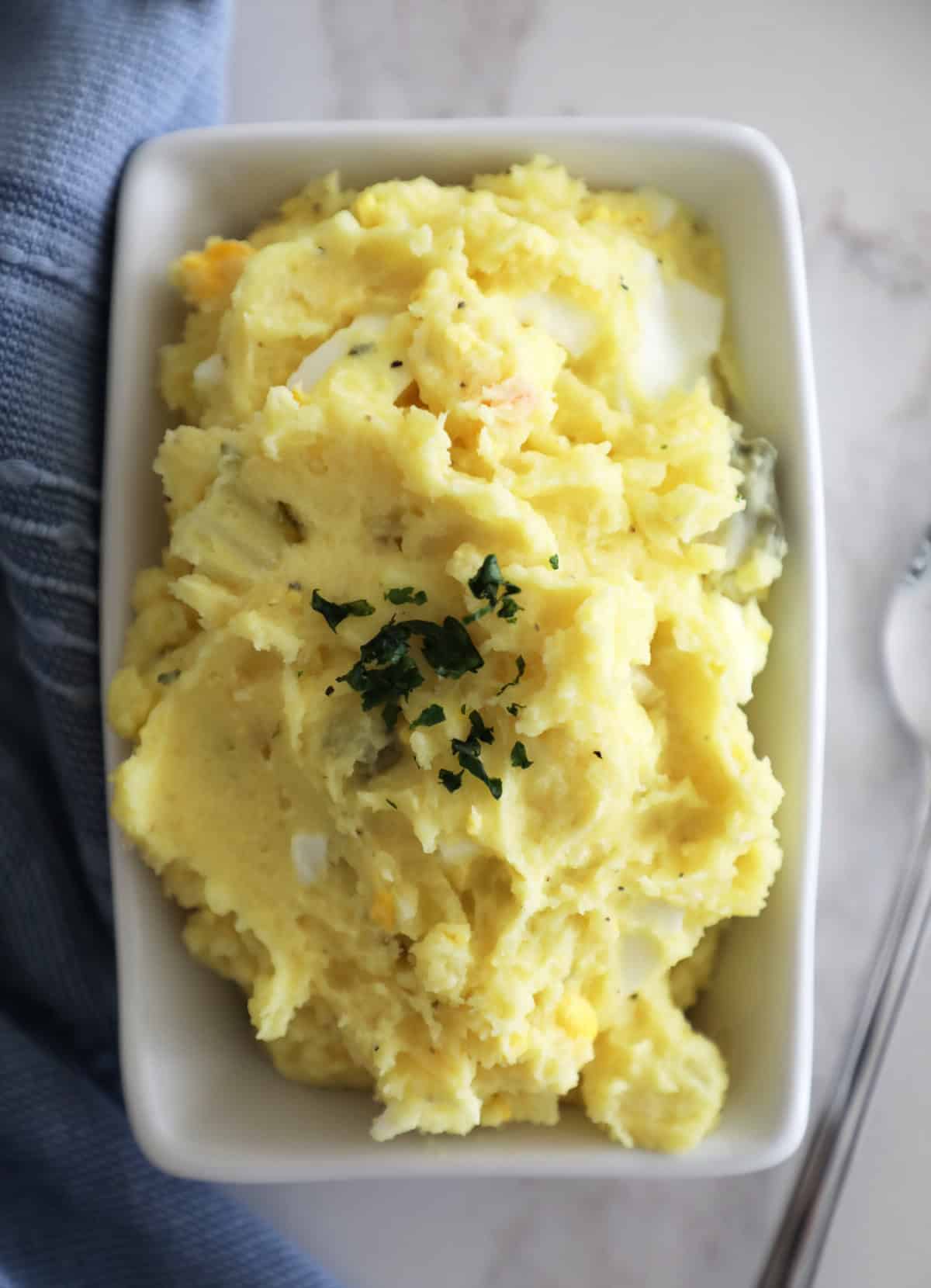 A close up bird's eye view of potato salad with fresh parsley on top. 