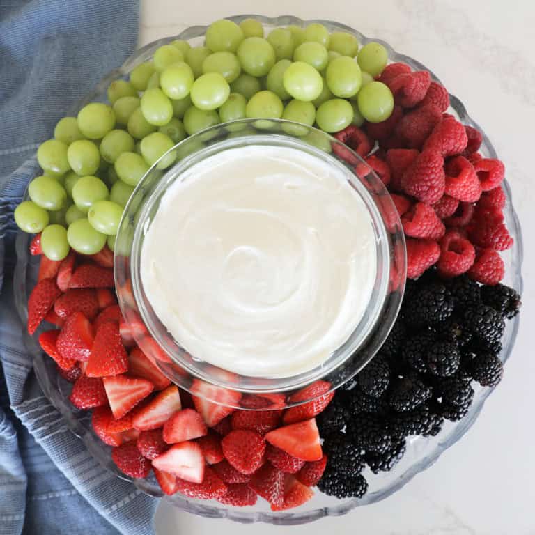 A bird's eye view of a fruit tray with homemade fruit dip in the center.