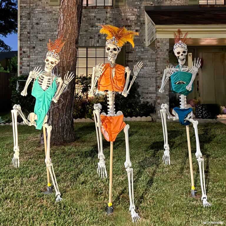 Funny skeleton display where three skeletons are wearing swimsuits and headpieces with feathers like showgirls.
