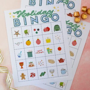 Holiday bingo cards representing winter holidays with gold-wrapped Rolo candy used as markers.