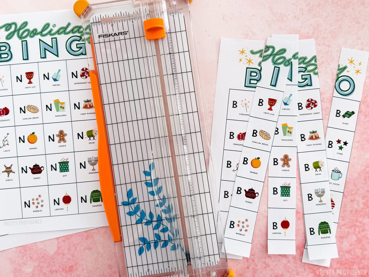 Holiday bingo calling cards being cut with a fiskars paper cutter.