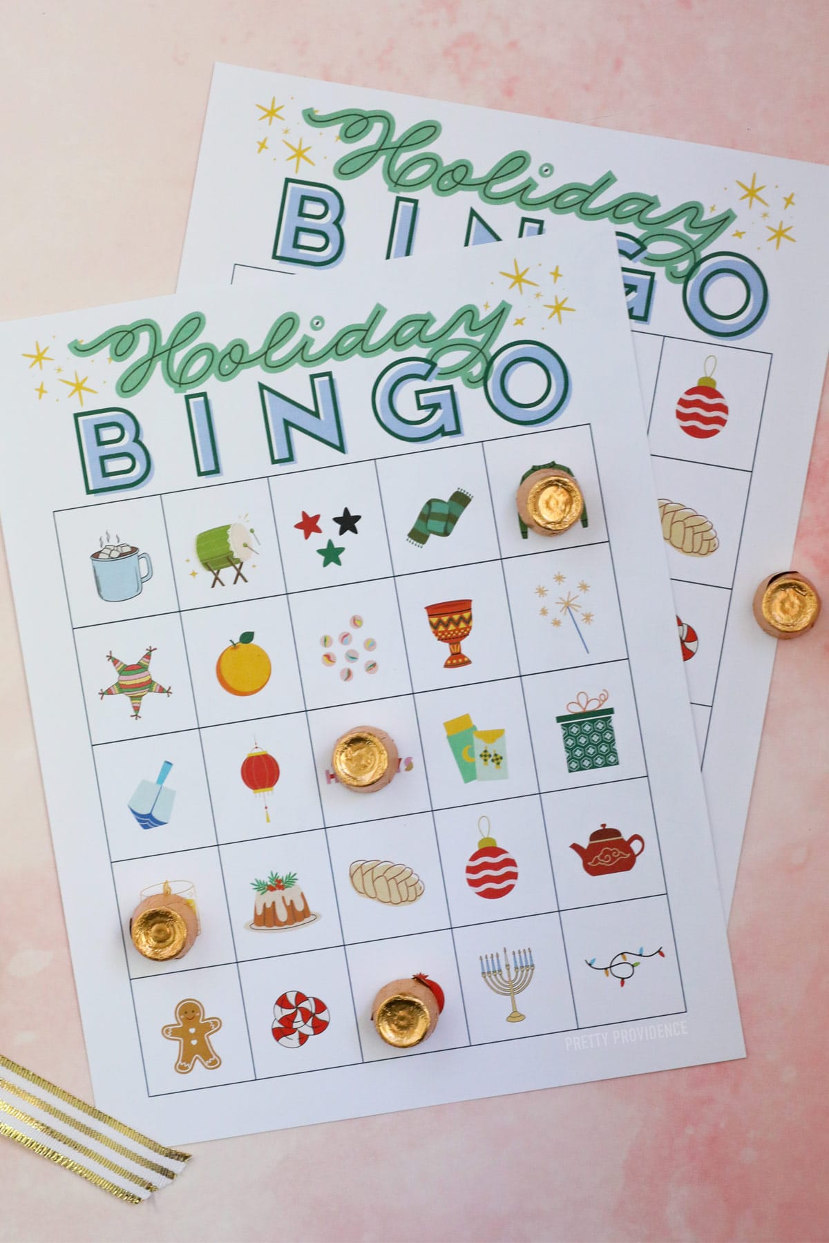 Holiday bingo cards representing winter holidays with gold-wrapped Rolo candy used as markers.