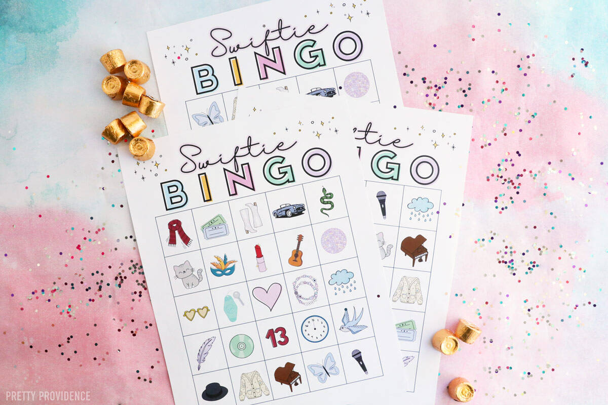 Printable Taylor Swift Themed Bingo Game Swiftie Bingo with themed pictures, on a flat lay with glitter and rolo candy on the side.