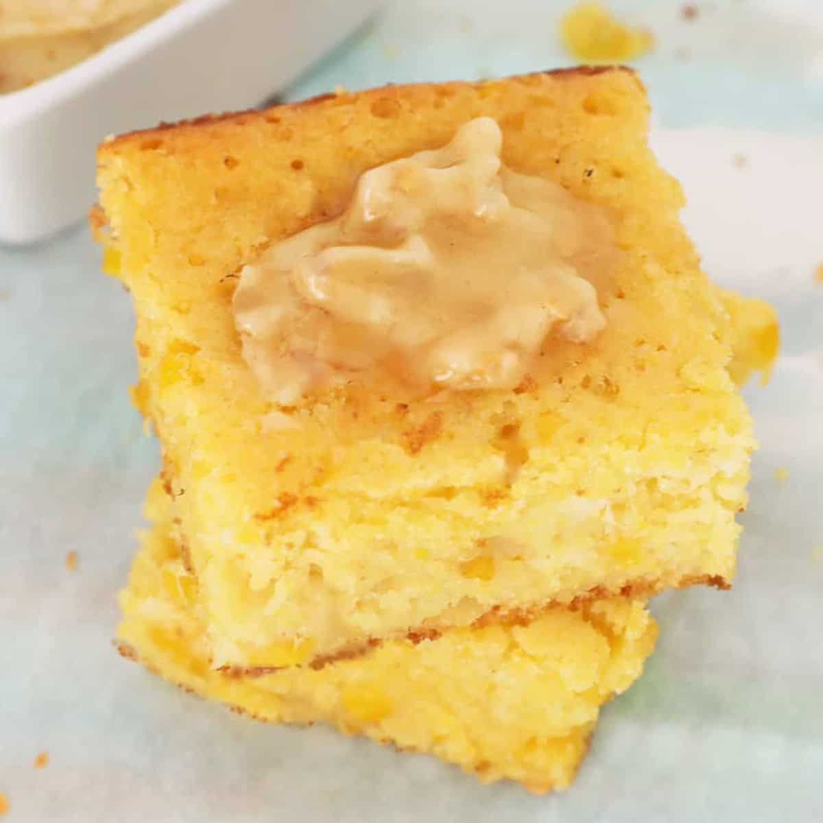 Two slices of semi homemade cornbread with honey butter on top.